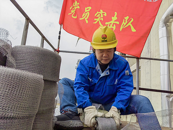 5月10日中午，在動力車間三期工藝除氧器平臺上，黨員突擊隊隊長李鑫正在纏繞新填料.jpg