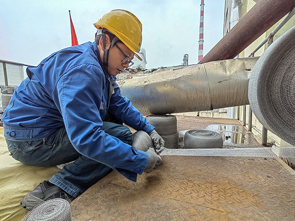 5月10日中午，在動力車間三期工藝除氧器平臺上，黨員突擊隊隊員劉瑞斌正在纏繞新填料.jpg