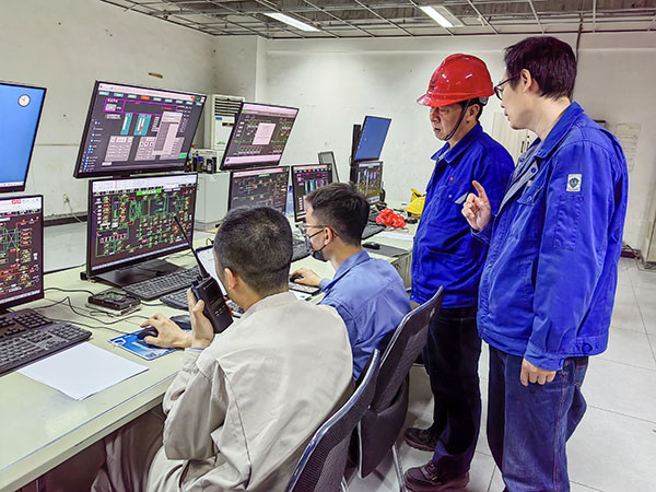 5月13日，動力車間三期鍋爐控制室，DCS改造工藝、儀表、電氣等部門聯(lián)合調試，車間主任姜軍虎與技術員畢加佳查看調試過程.jpg