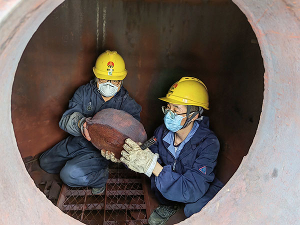 5月11日，動力車間三期工藝除氧器內(nèi)部，黨員突擊隊隊員劉瑞斌和李震正在清理舊填料.jpg