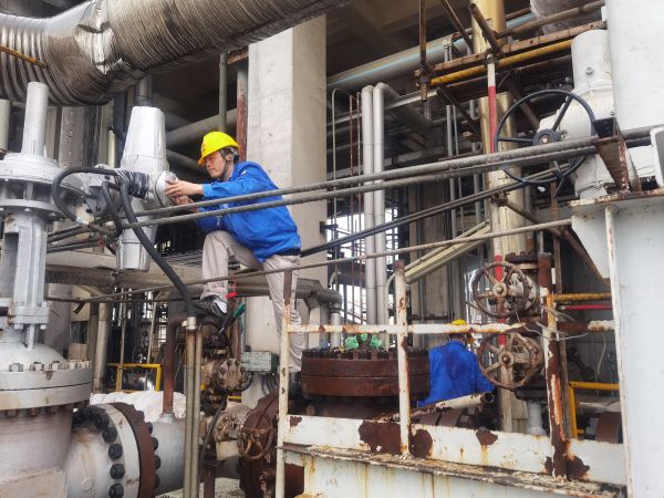 氣化爐上，柳曦、徐騰飛冒雨調(diào)試氣化爐電動(dòng)閥.jpg