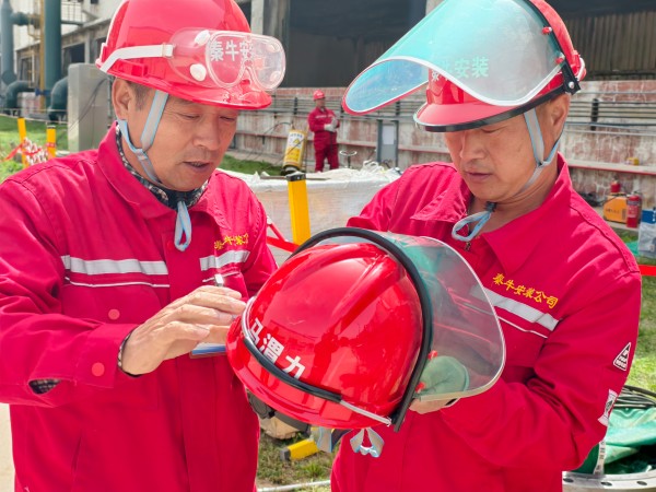 團結協(xié)作 施工人員正在為其工友安裝安全面罩.jpg